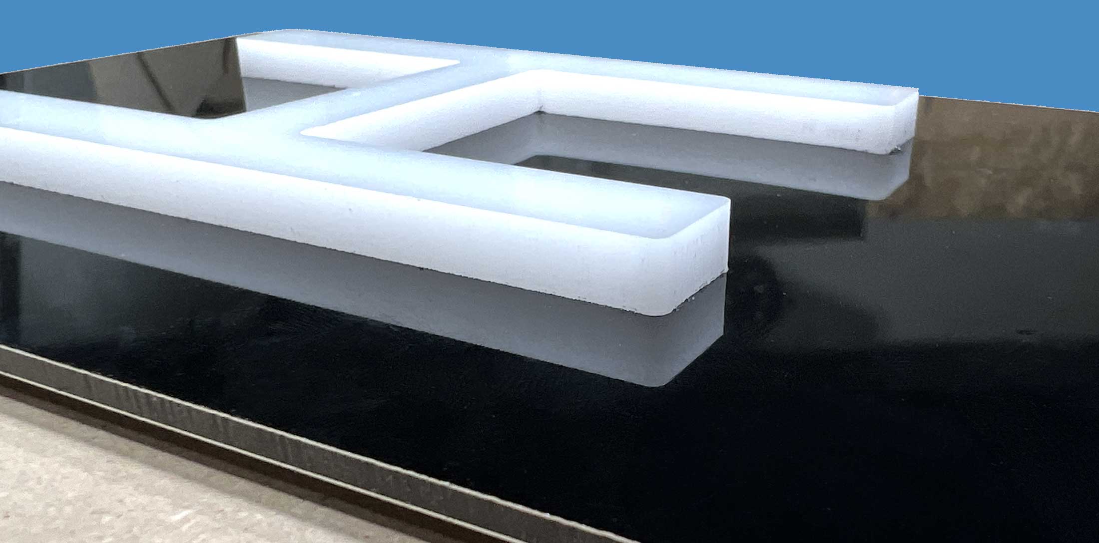 Acrylic letter mounted to black ACM max metal