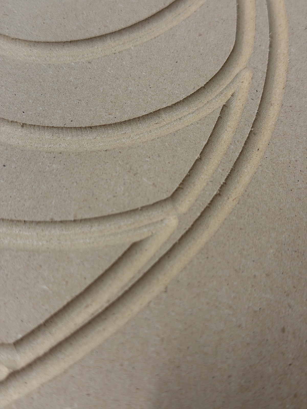 Close-up of the failed test cut showing wide fuzzy channels with torn edges instead of clean engraved lines
