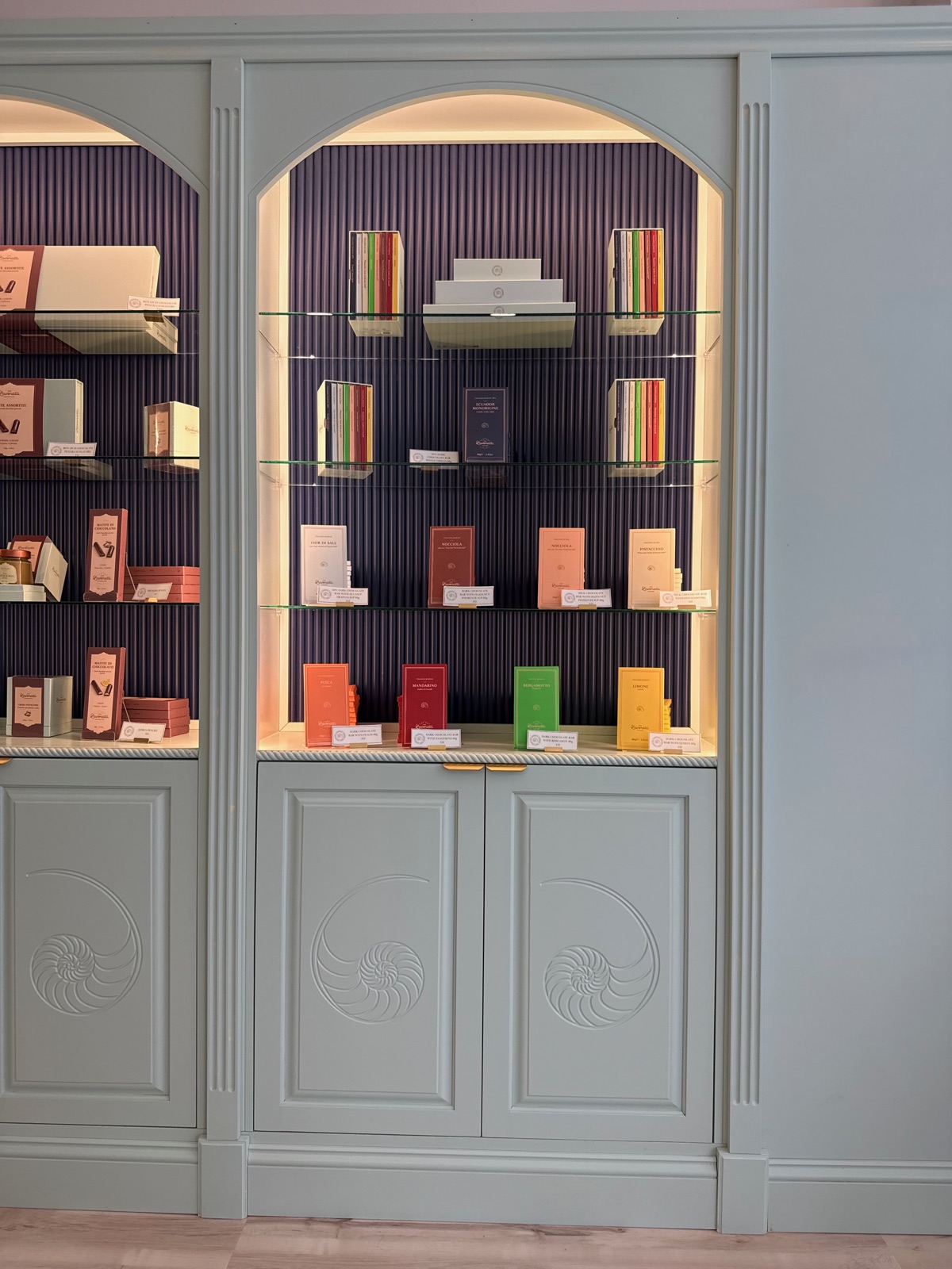 Finished showroom cabinetry with the nautilus engraving reading tone on tone beneath a lit arched display niche