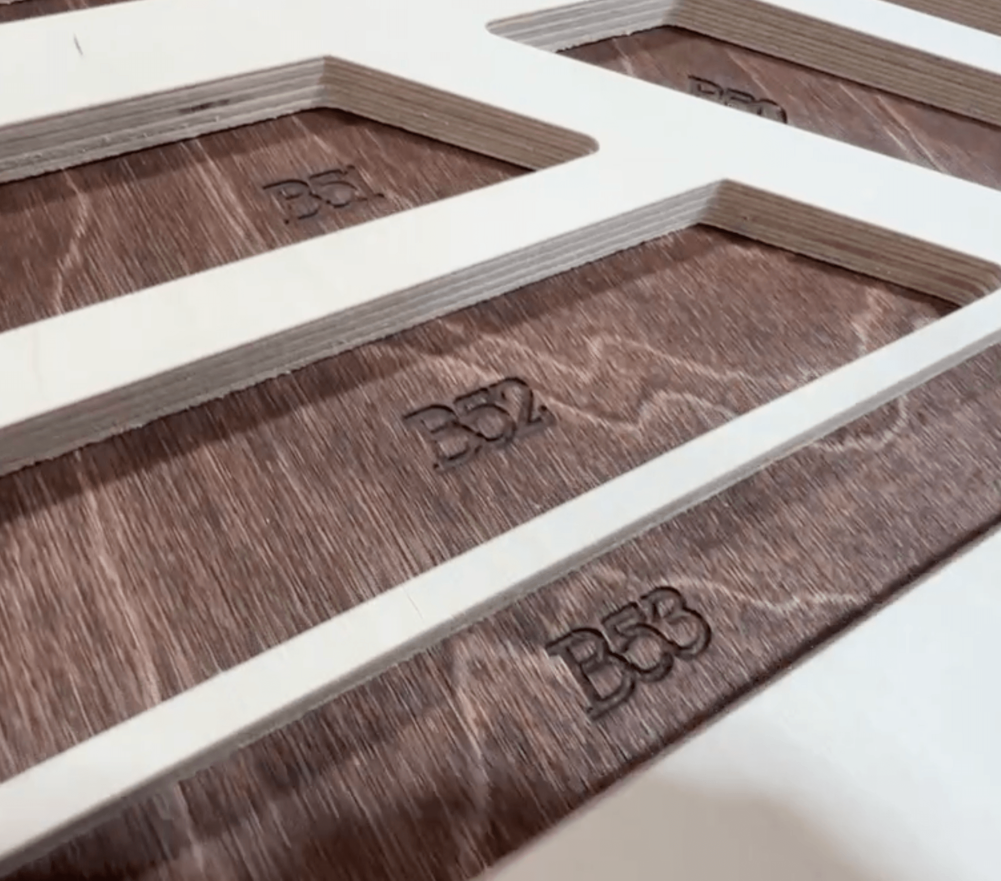 Close-up of the engraved numbered key on a backing board with stained top pieces queued for placement