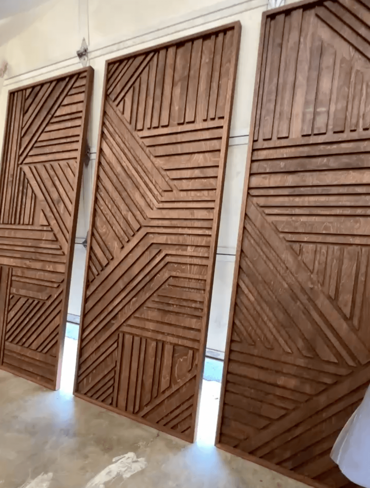 Three finished wall art panels lined up in the shop, ready for install